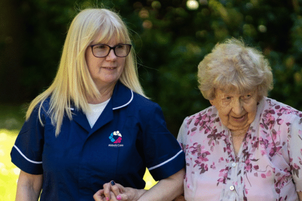Abbots Care Worker and an elderly client go walking on a sunny day