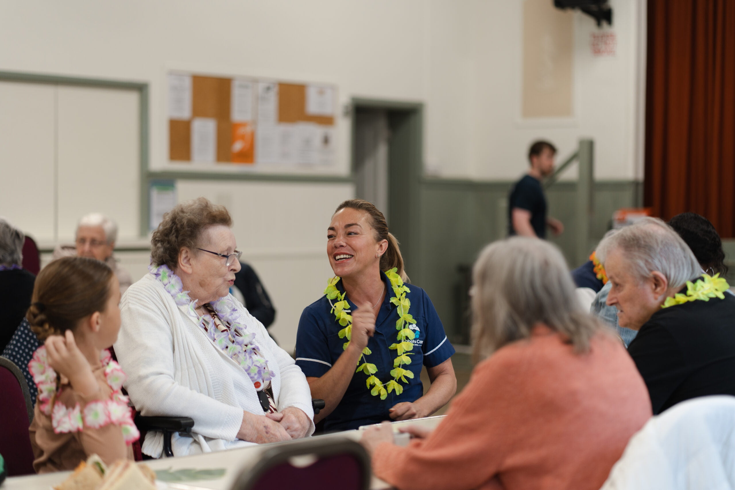 Client and Care Worker laugh together at a summer tea party