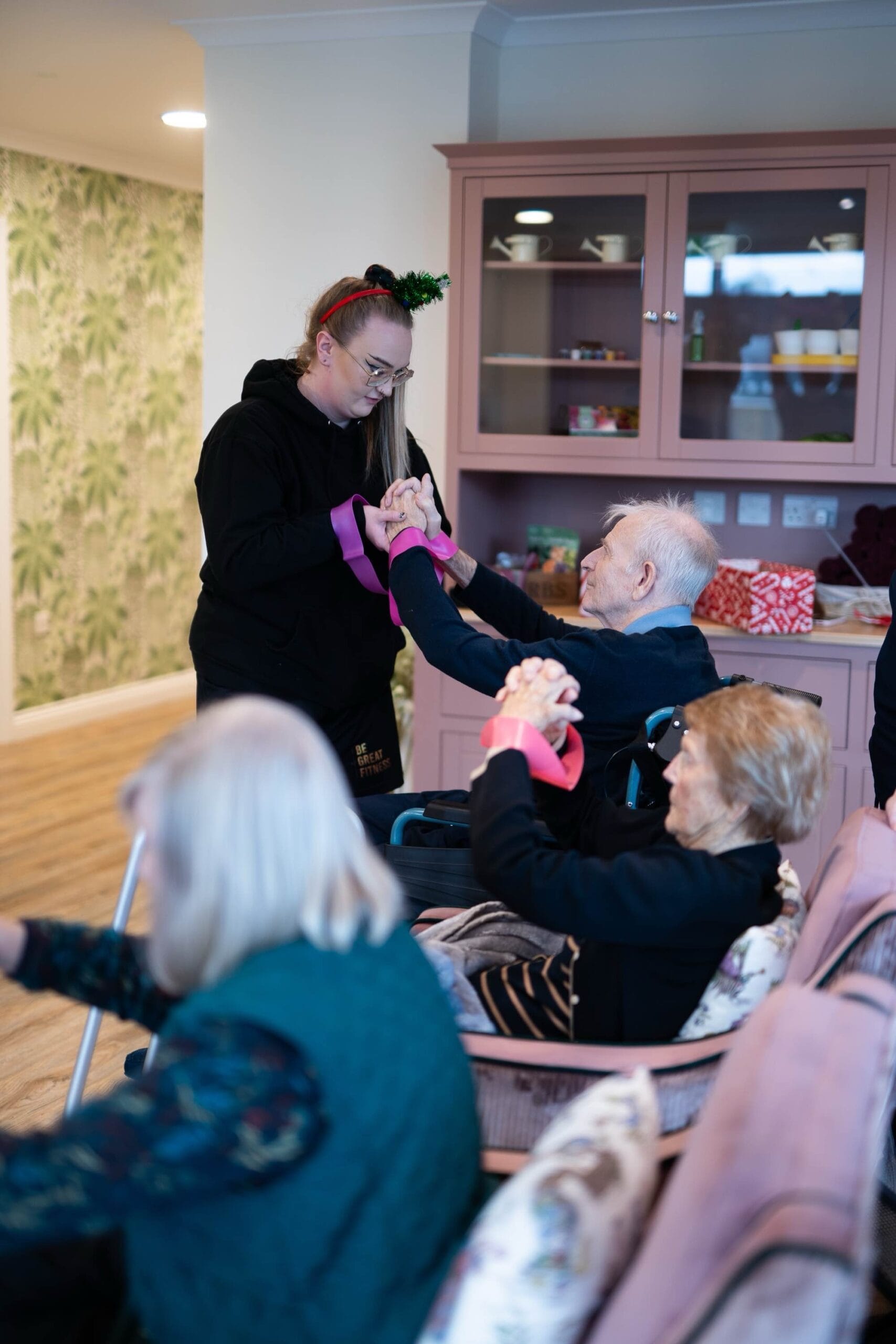 A member of the BeGreatFitness team delivering an accessible exercise class to elderly people in a care home