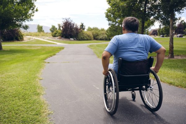 Man living with a spinal cord injury in a wheelchair in a park