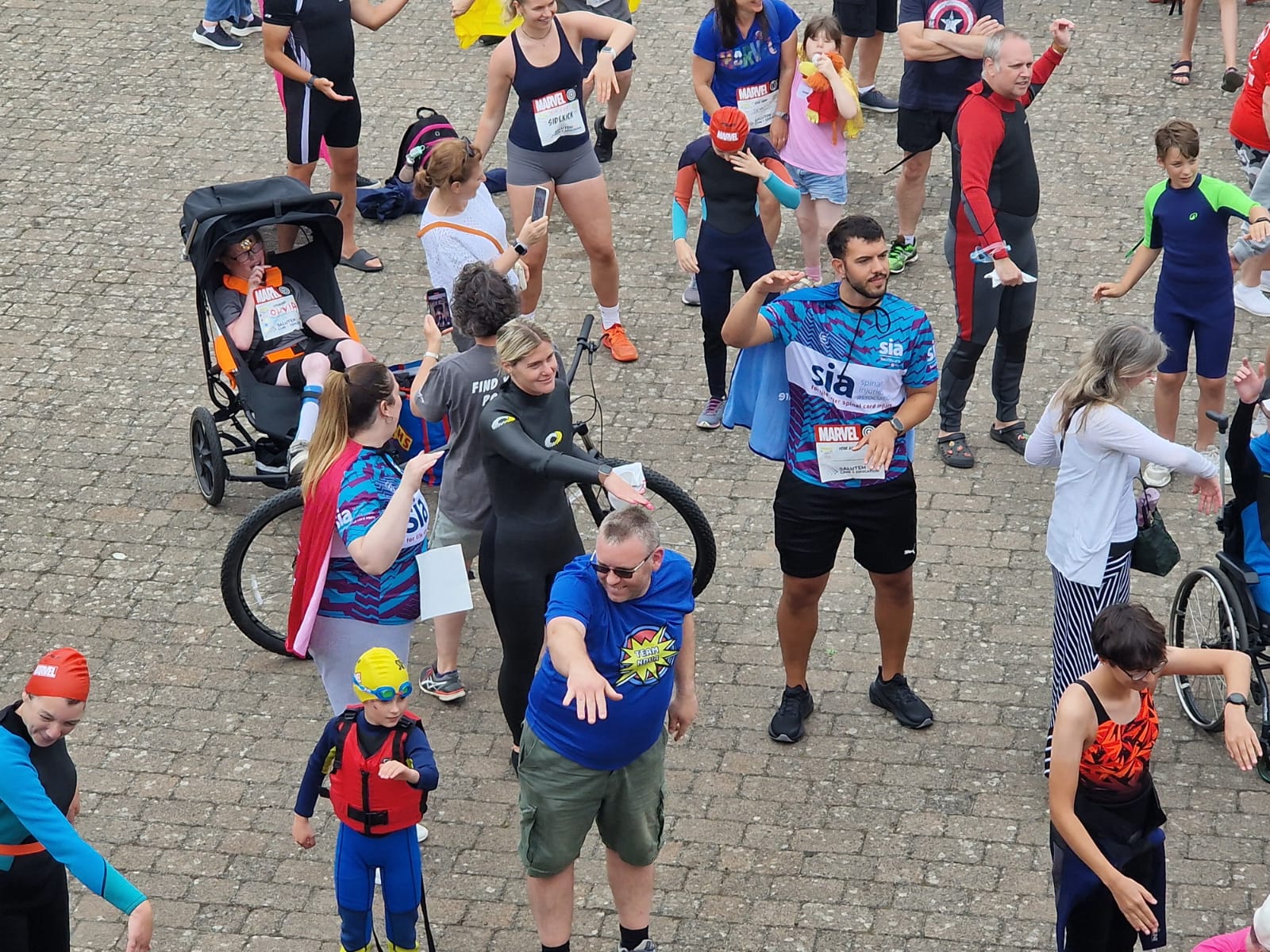 Abbots Care colleague Veiz smiling and dancing the Macarena in the crowd at the Superhero Triathlon.