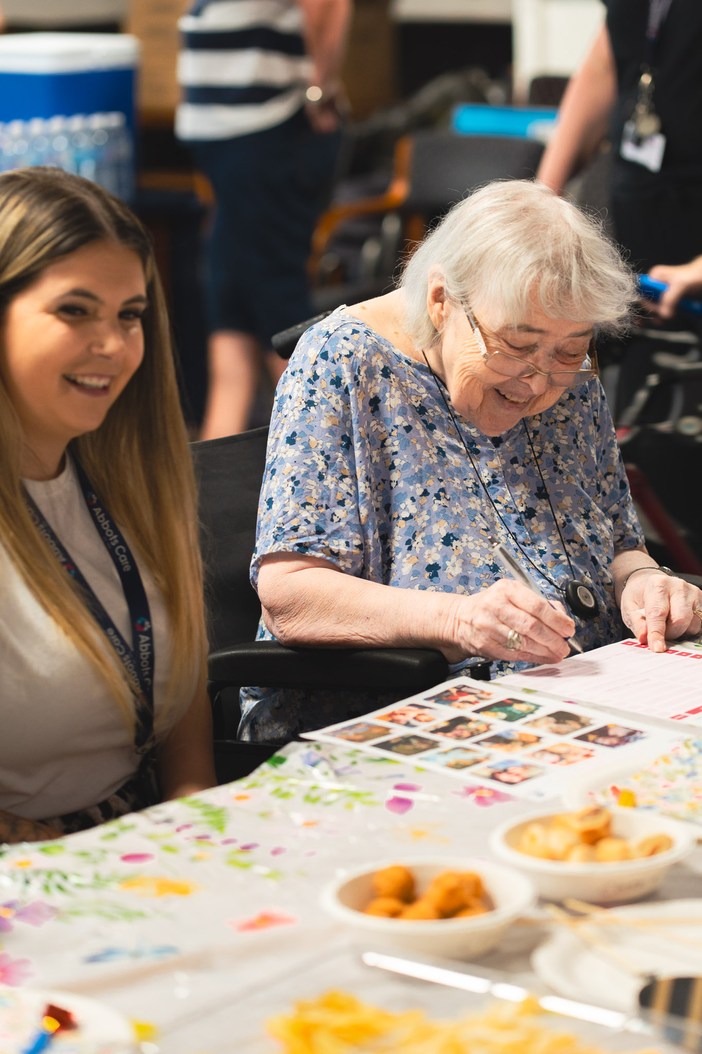 Abbots Care community facilitator Charlie pictured taking part in a quiz with a client at a tea party