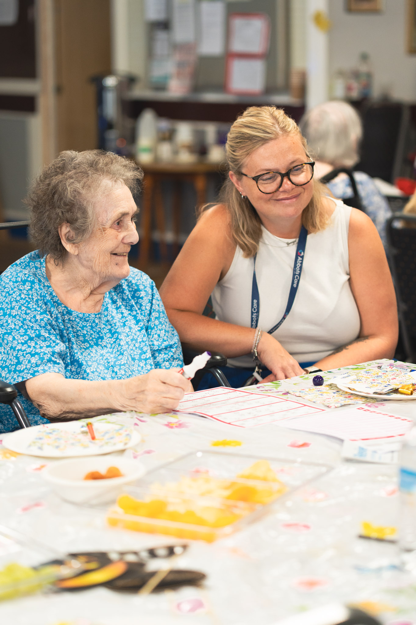 Avril from our central support team smiles with a client at one of our community tea parties